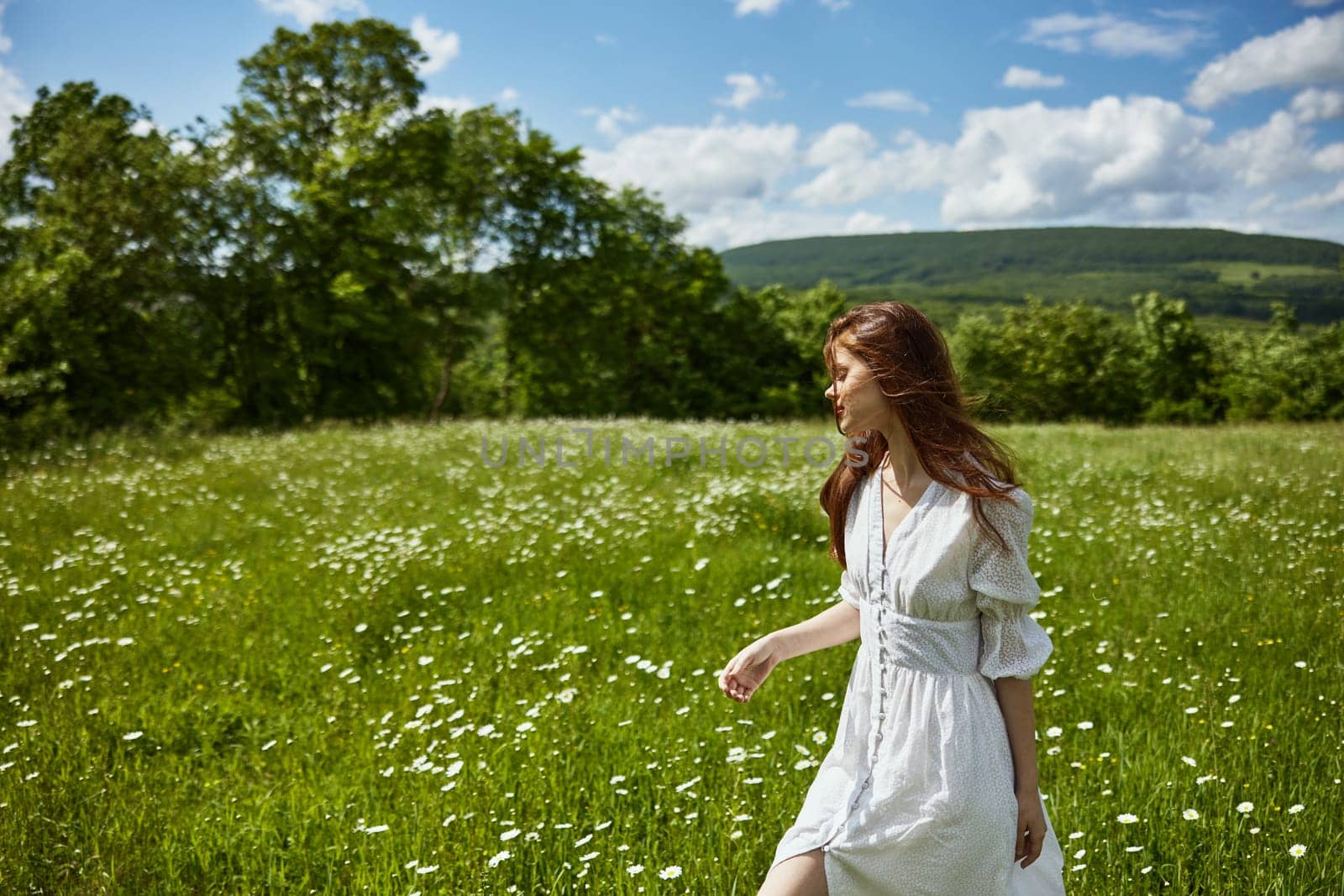 portrait of a woman in a light dress in a chamomile field turning her face away from the camera. High quality photo