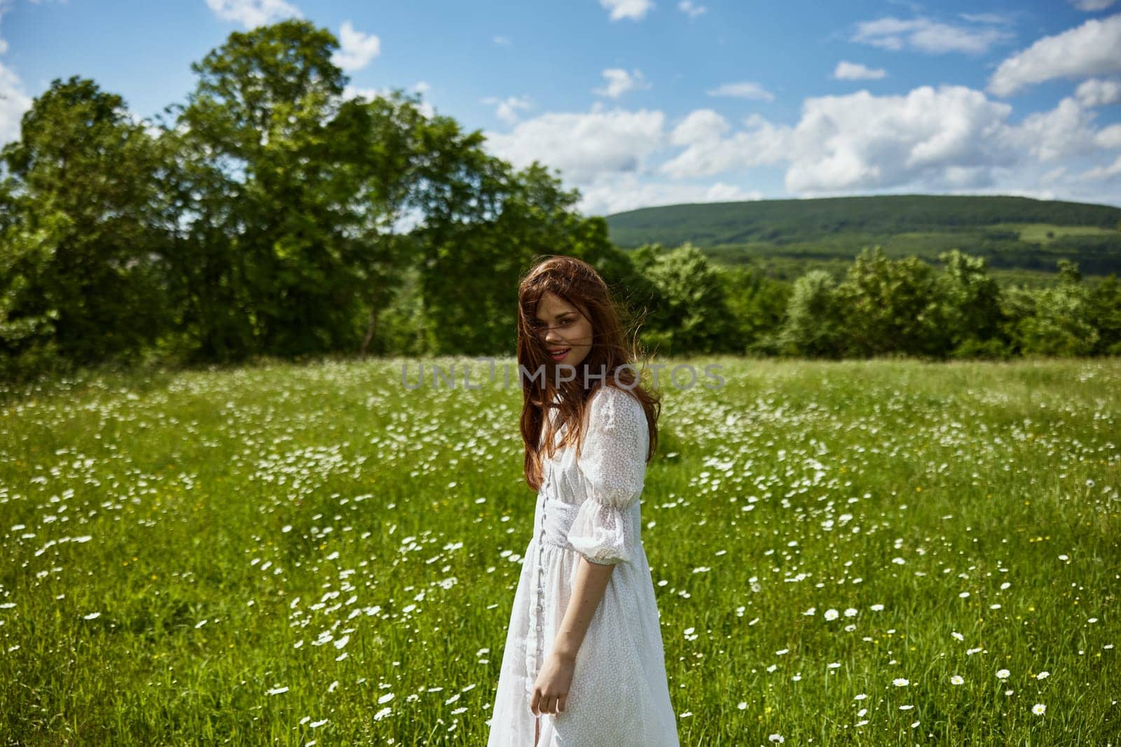 portrait of a woman in a light dress in a chamomile field turning her face away from the camera. High quality photo
