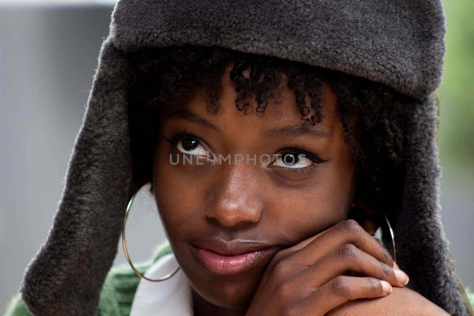 closeup of pretty african american girl in russian military hat looking up and thoughtful by Raulmartin