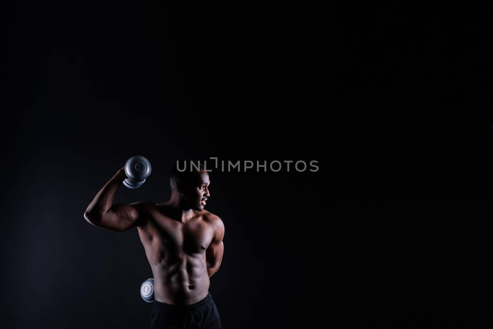 Portrait of happy african man with dumbbells over red and black background