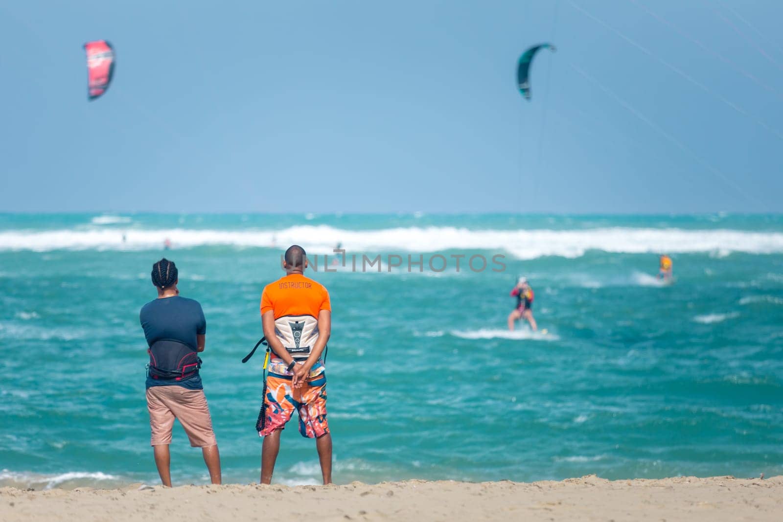 Active sporty people enjoying kitesurfing holidays and activities on perfect sunny day on Cabarete tropical sandy beach in Dominican Republic. by kasto