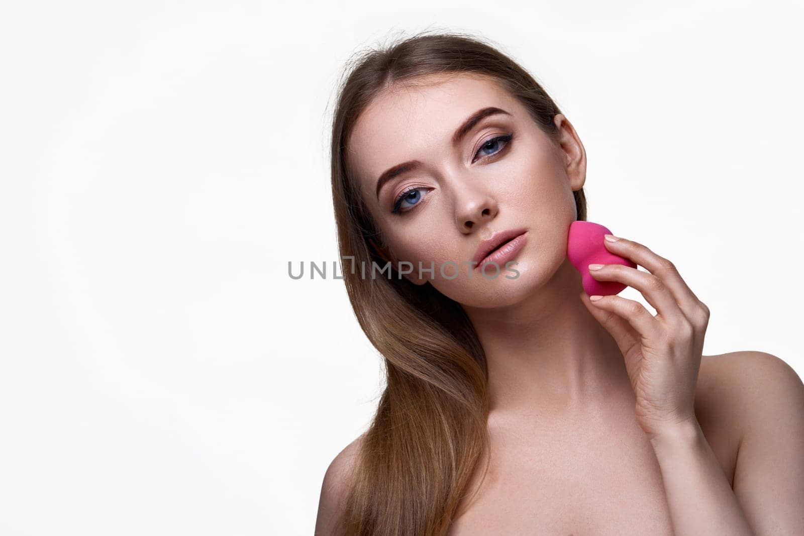 attractive young woman using pink cosmetic sponges isolated on white background