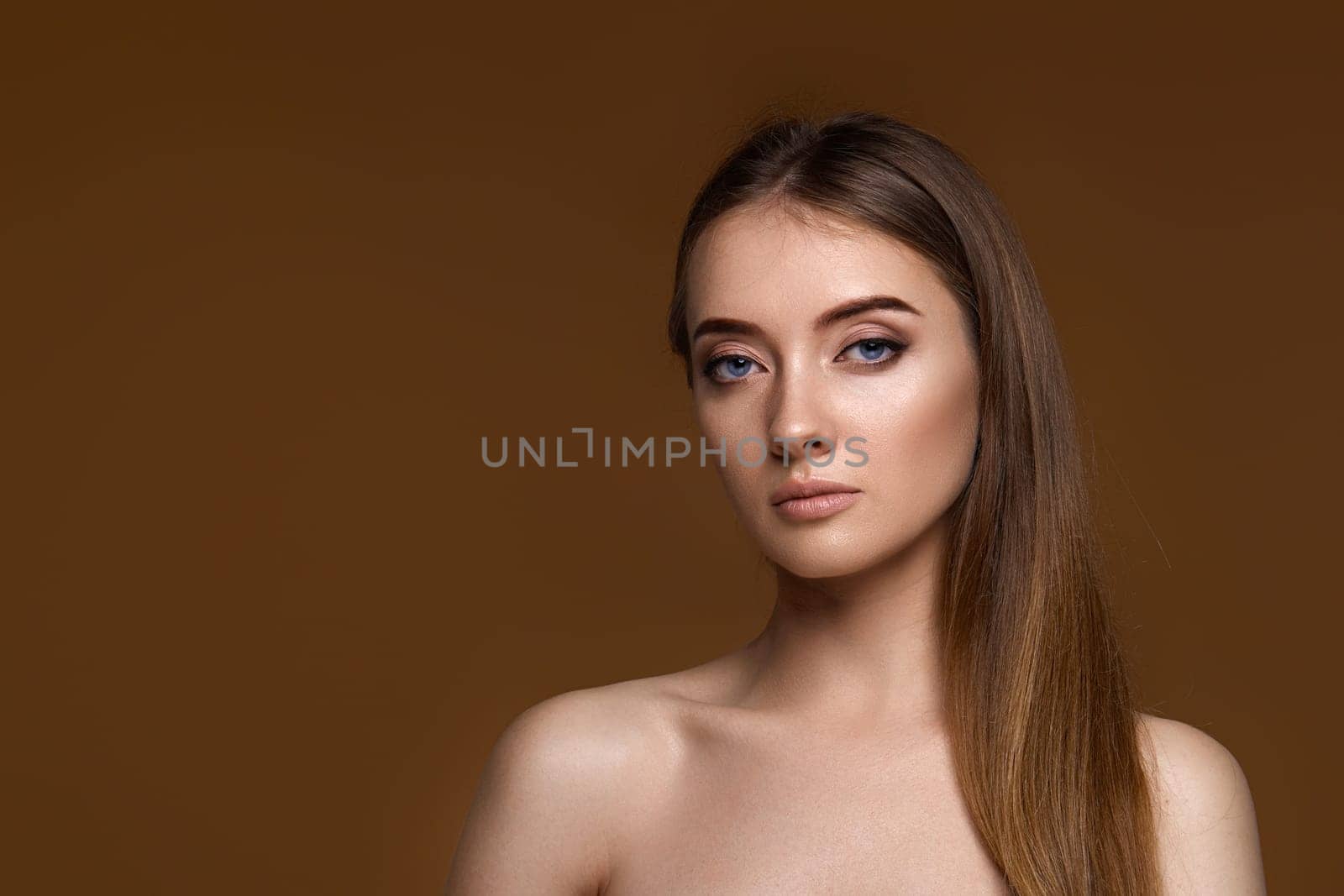portrait of beautiful young woman with perfect skin on beige background. copy space