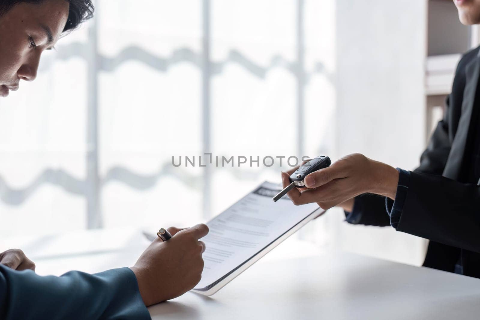 Loan approver, businessman giving car keys after car loan approval and contract signing.