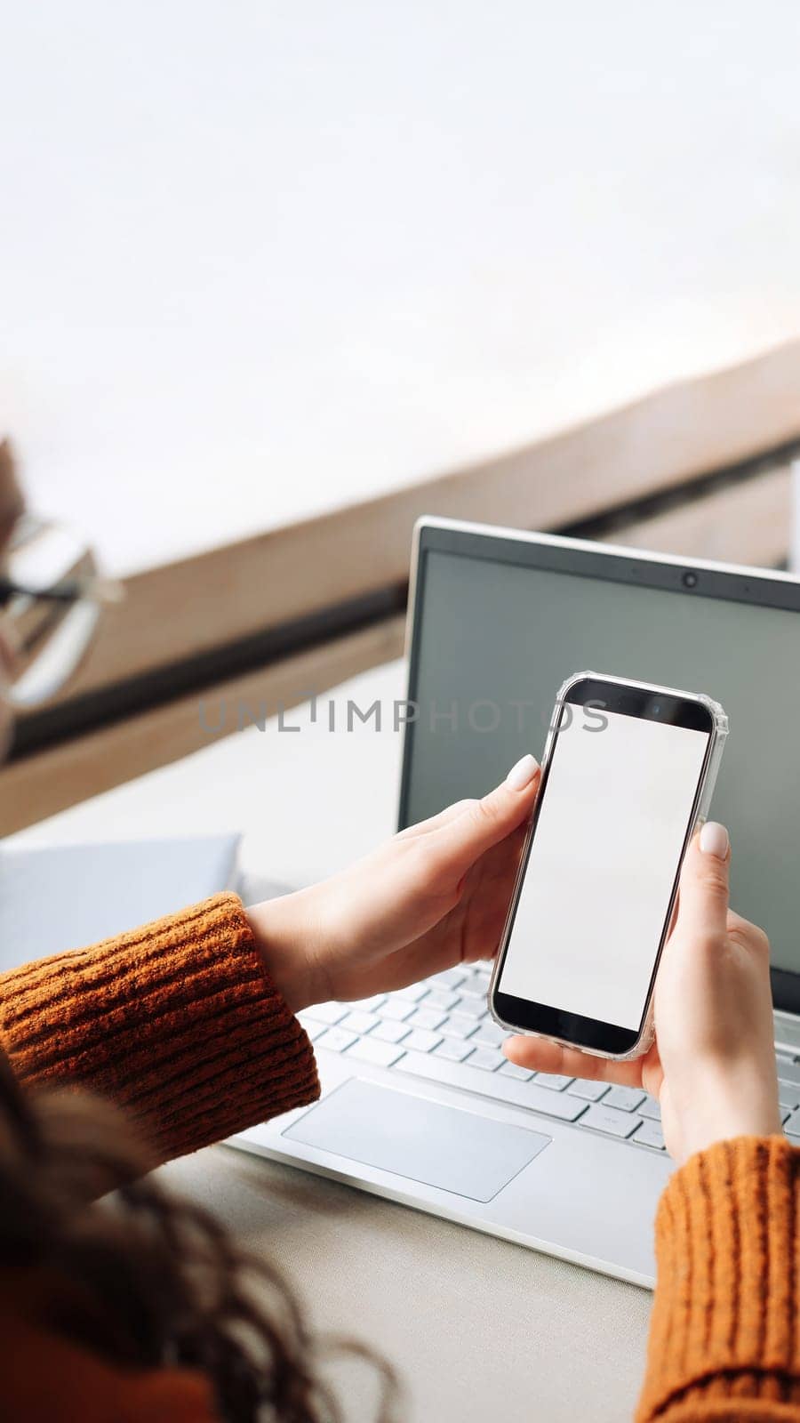 Stylish woman uses smartphone with white blank screen to promote apps. Modern woman uses smartphone with white blank screen to promote and advertise apps, shoulder view, cell phone.