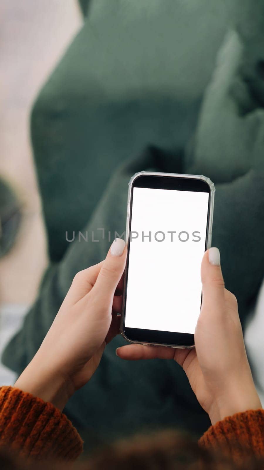 Relaxed Woman Using Smartphone Apps on Sofa at Home - Over Shoulder View with Cellphone Display Mock Up for Advertising Concept.