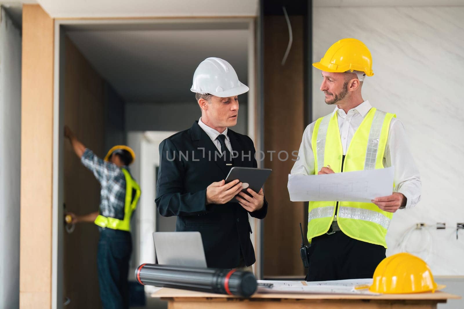 Professional construction engineers team using blueprint of project plan brainstorming and working together at construction building, Architecture and building construction concept.