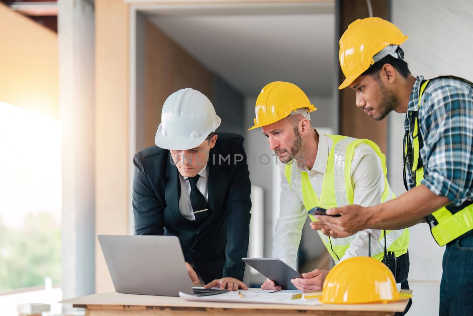 Team Engineers with draft plan of building on constructing site. Engineer work on site. Inspector engineer check and working on site.