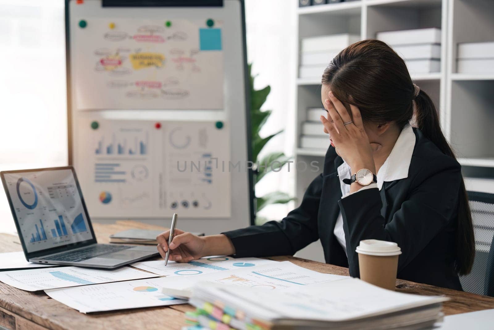 Asian business women are stressed while working on laptop and pile of documents, Tired asian businesswoman with headache at office, feeling sick at work.