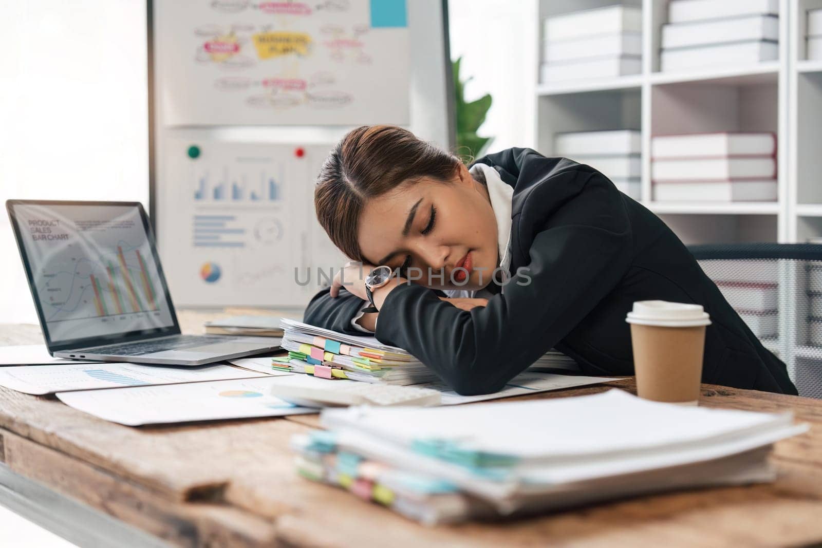 tired business woman sleepy and bored from sitting at a desk for a long time and has office syndrome by nateemee