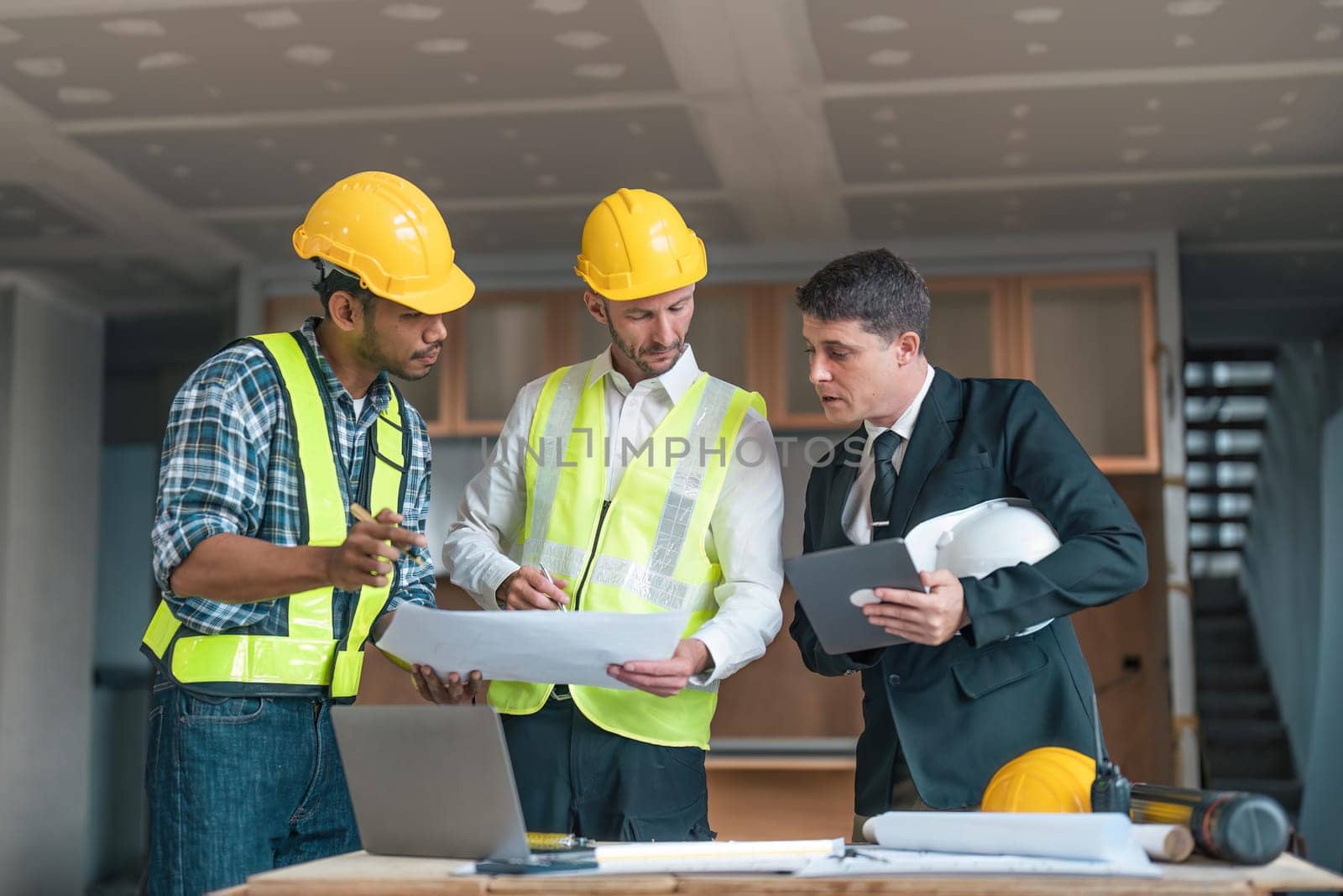 Professional construction engineers team using blueprint of project plan brainstorming and working together at construction building, Architecture and building construction concept.