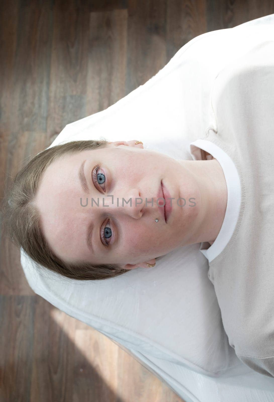 Portrait Of Caucasian Young Woman After Eyelash Lamination Procedure, Lash Treatment Lying on Couch. Top View. Vertical Plane High quality photo by netatsi