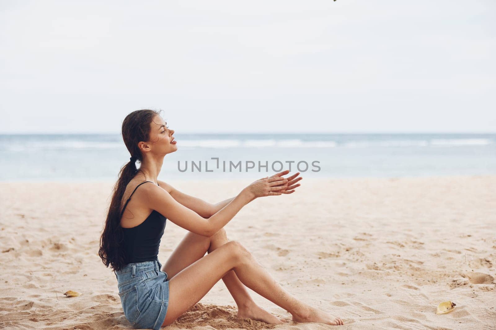 back woman freedom coast female beach sitting sea sand view alone white smile vacation ocean beautiful hair model tropical young nature travel