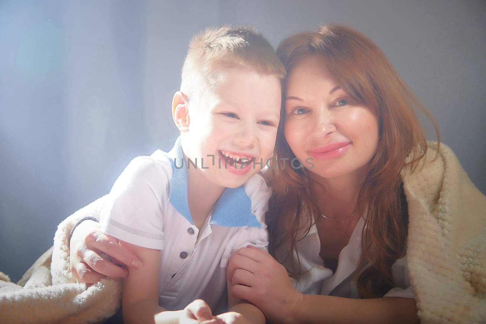 Woman with a boy. Mom with son on a white background. Family portrait with mother and boy having fun together by keleny