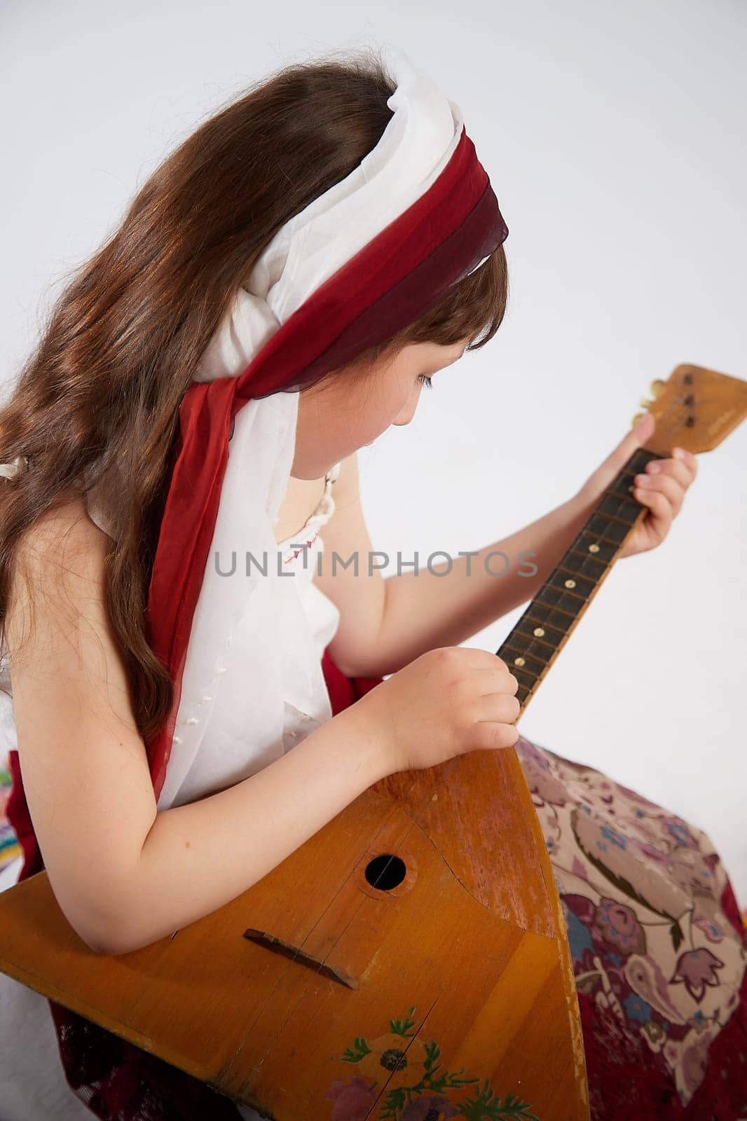 Portrait of Little girl in a stylized Tatar national costume on a white background in the studio. Photo shoot of funny young teenager who is not a professional model