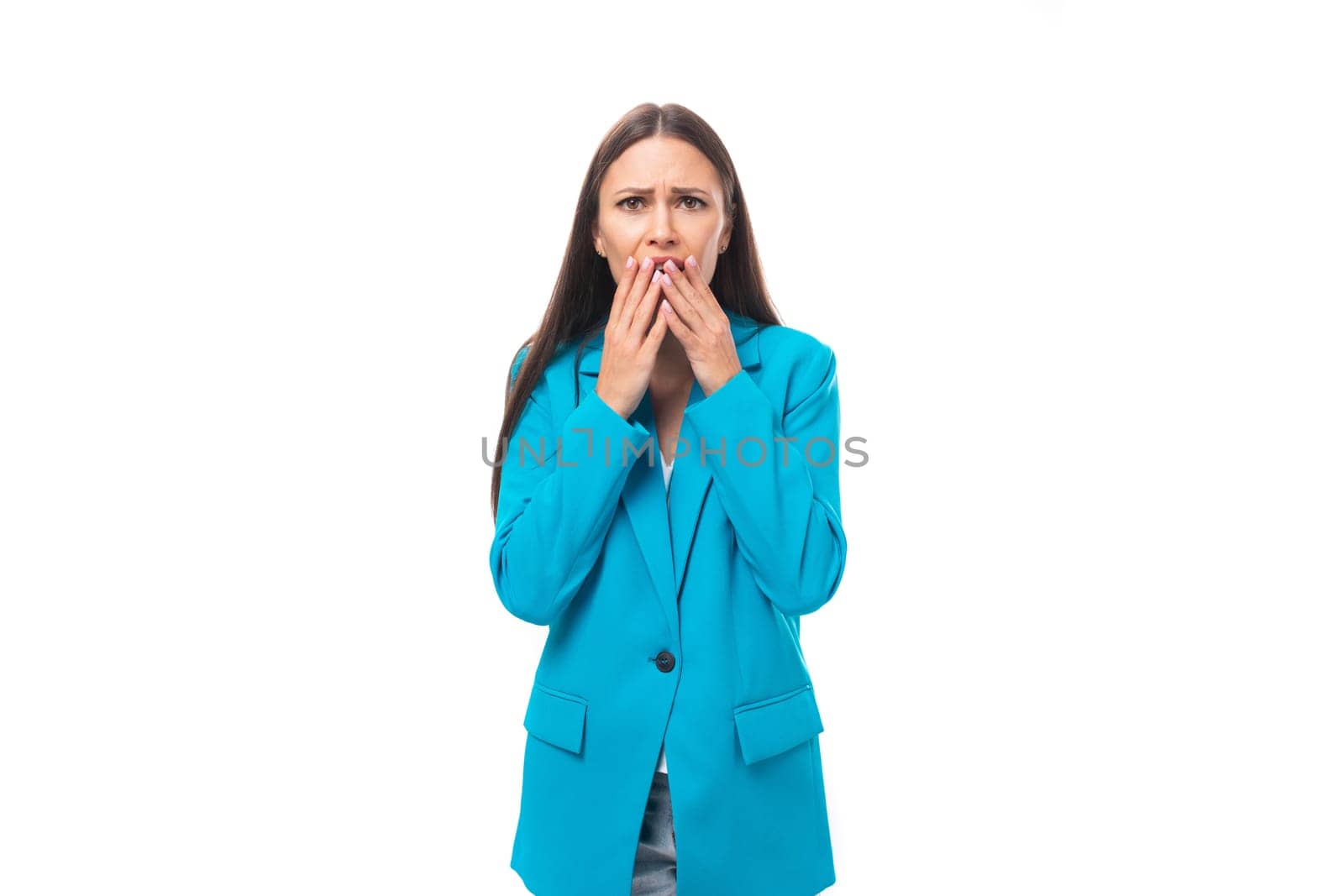 young attractive office worker woman with black straight hair in a blue business jacket is surprised on a white background with copy space by TRMK