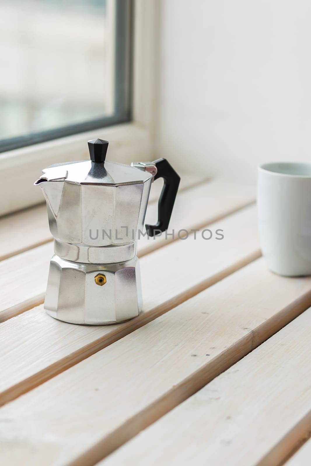 Moka pot and coffee cup on windowsill - drinks and breakfast concept by Satura86