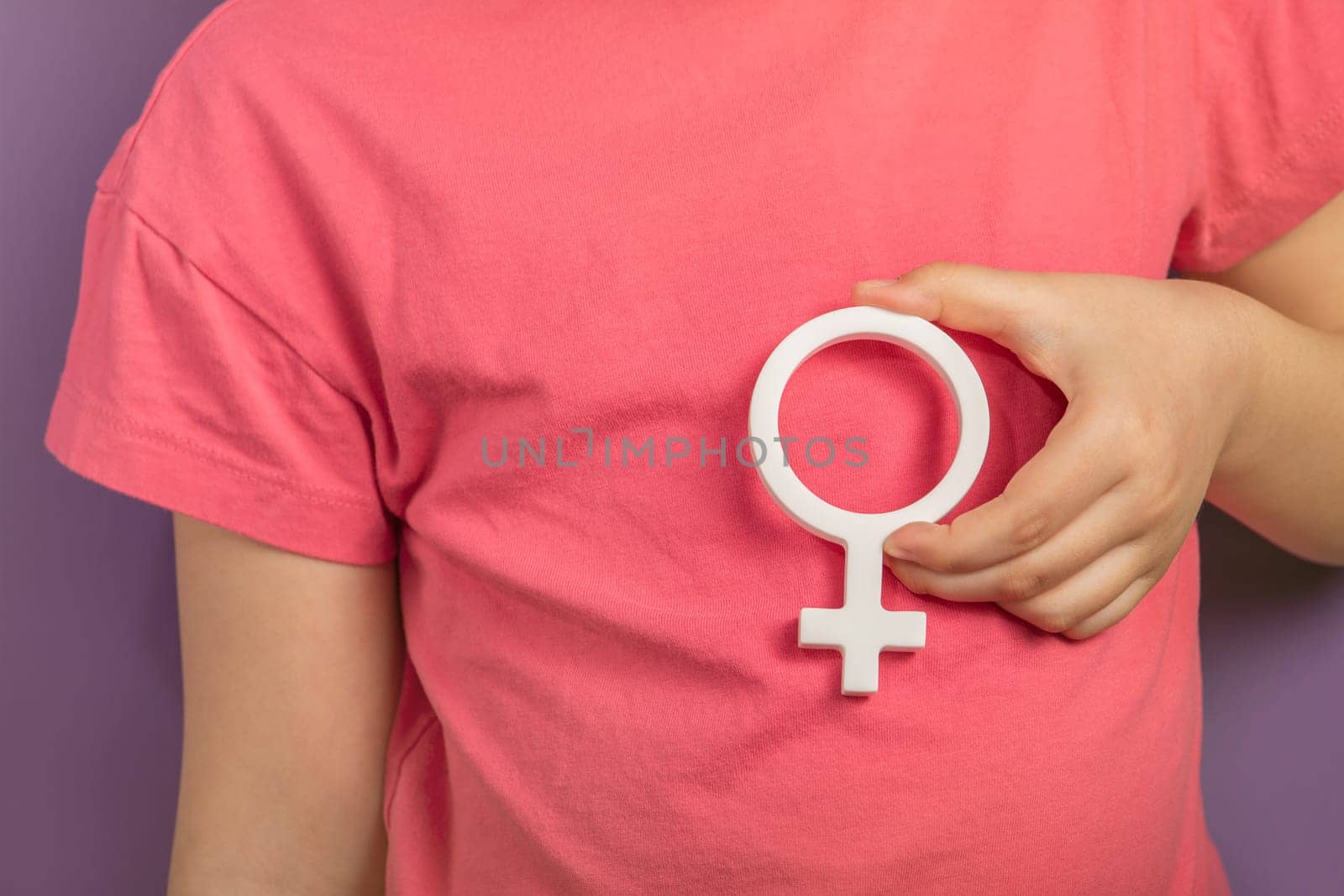 Gender symbol of a woman. Banner with woman symbol in hands on purple background with copy space. The concept of female discrimination, leadership or domestic violence protest