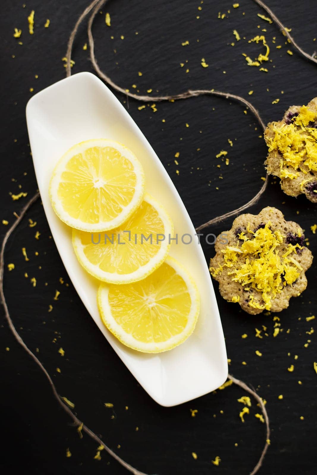 lemon cupcakes on a black background with lemon zest