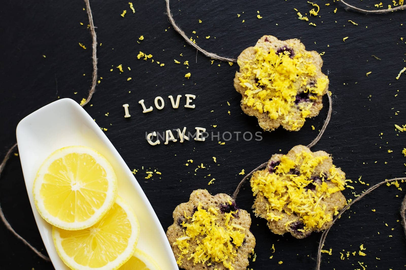 lemon cupcakes on a black background with lemon zest, inscription I love cake, close-up