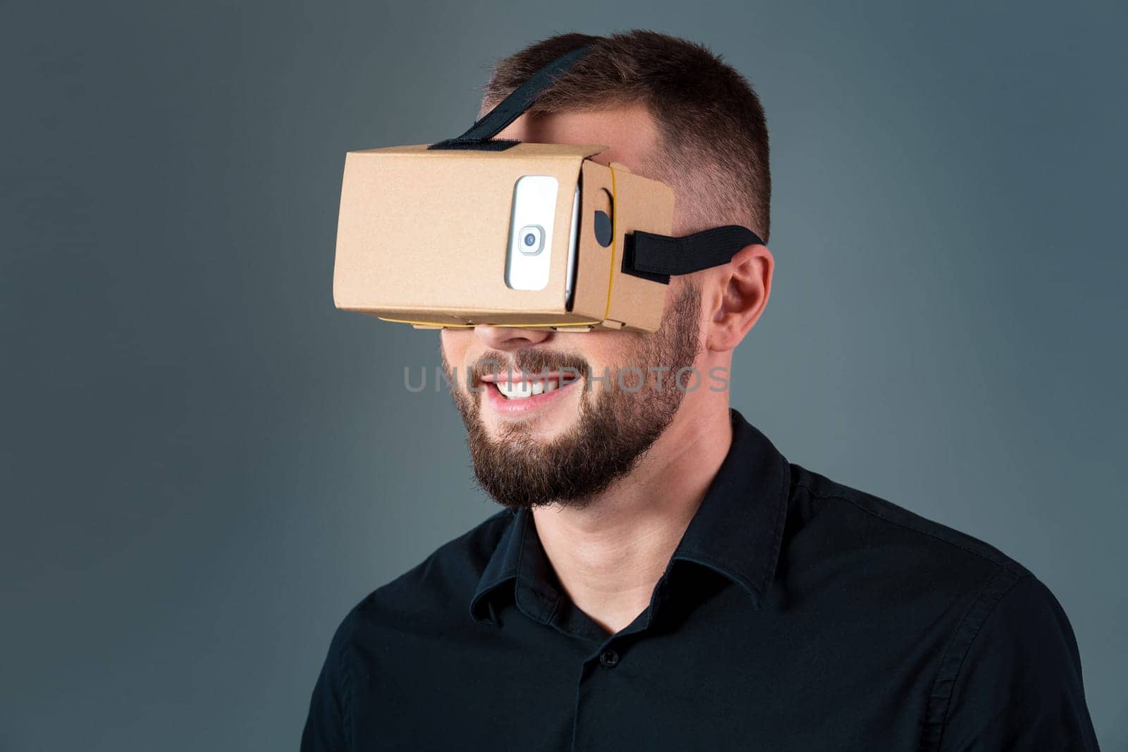 Man using a new virtual reality headset on grey background. Men's emotions