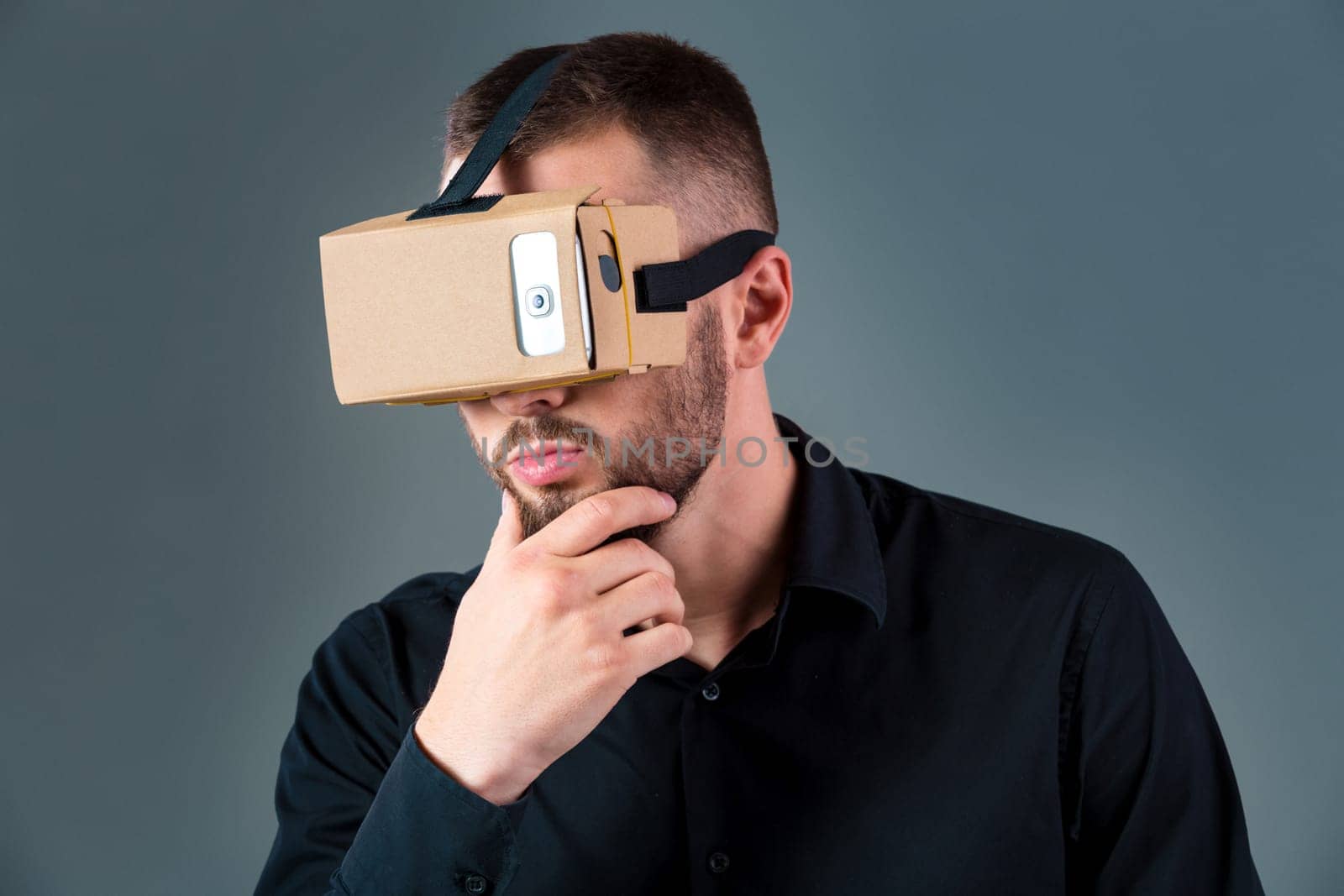 Man using a new virtual reality headset on grey background. Men's emotions