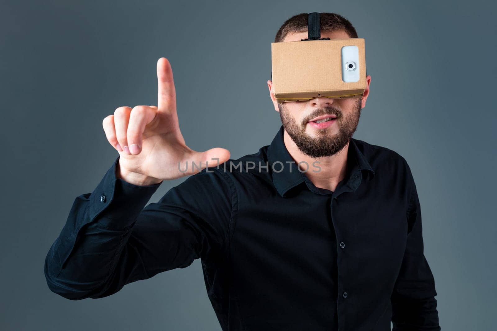 Man using a new virtual reality headset on grey background. Men's emotions