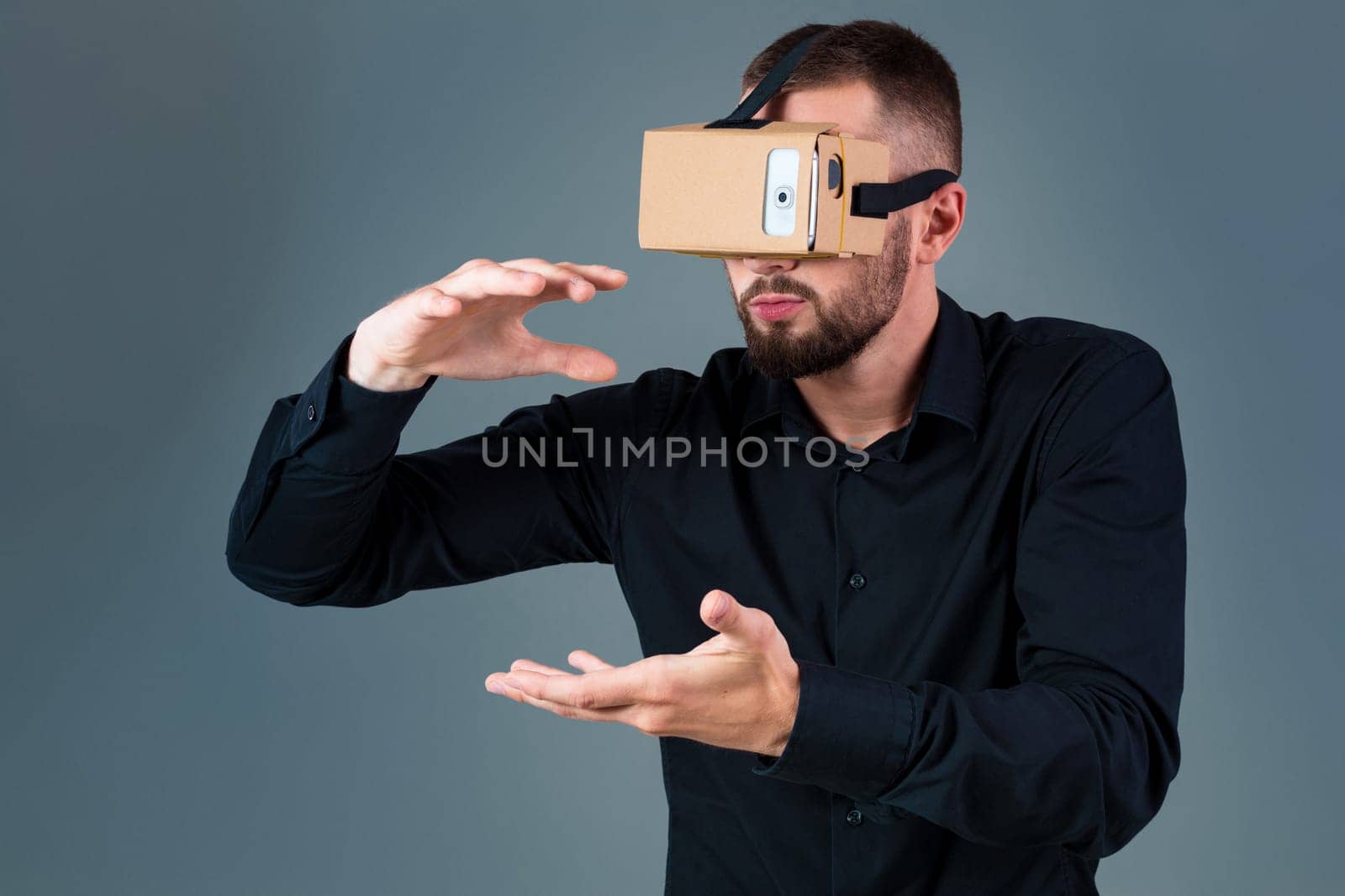 Man using a new virtual reality headset on grey background. Men's emotions