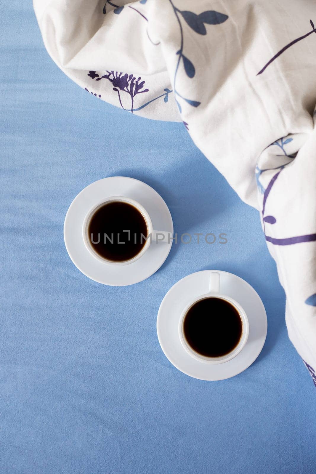 Two white cups of coffee are in bed by sfinks