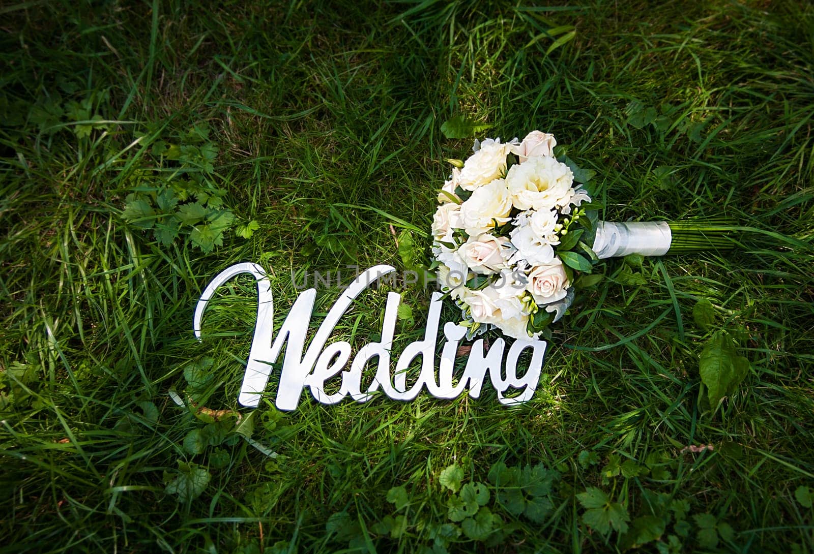 Word of wedding and bridal bouquet outdoor.