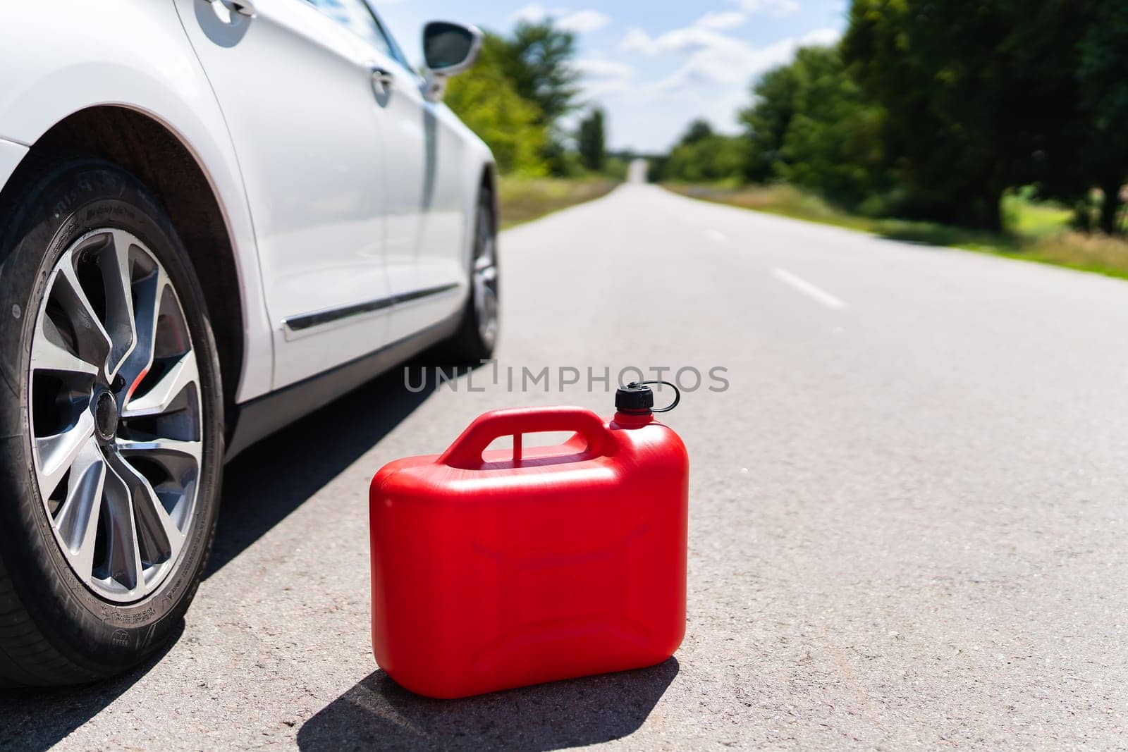 Empty car tank from a red canister on the side of the road. Fuel problem