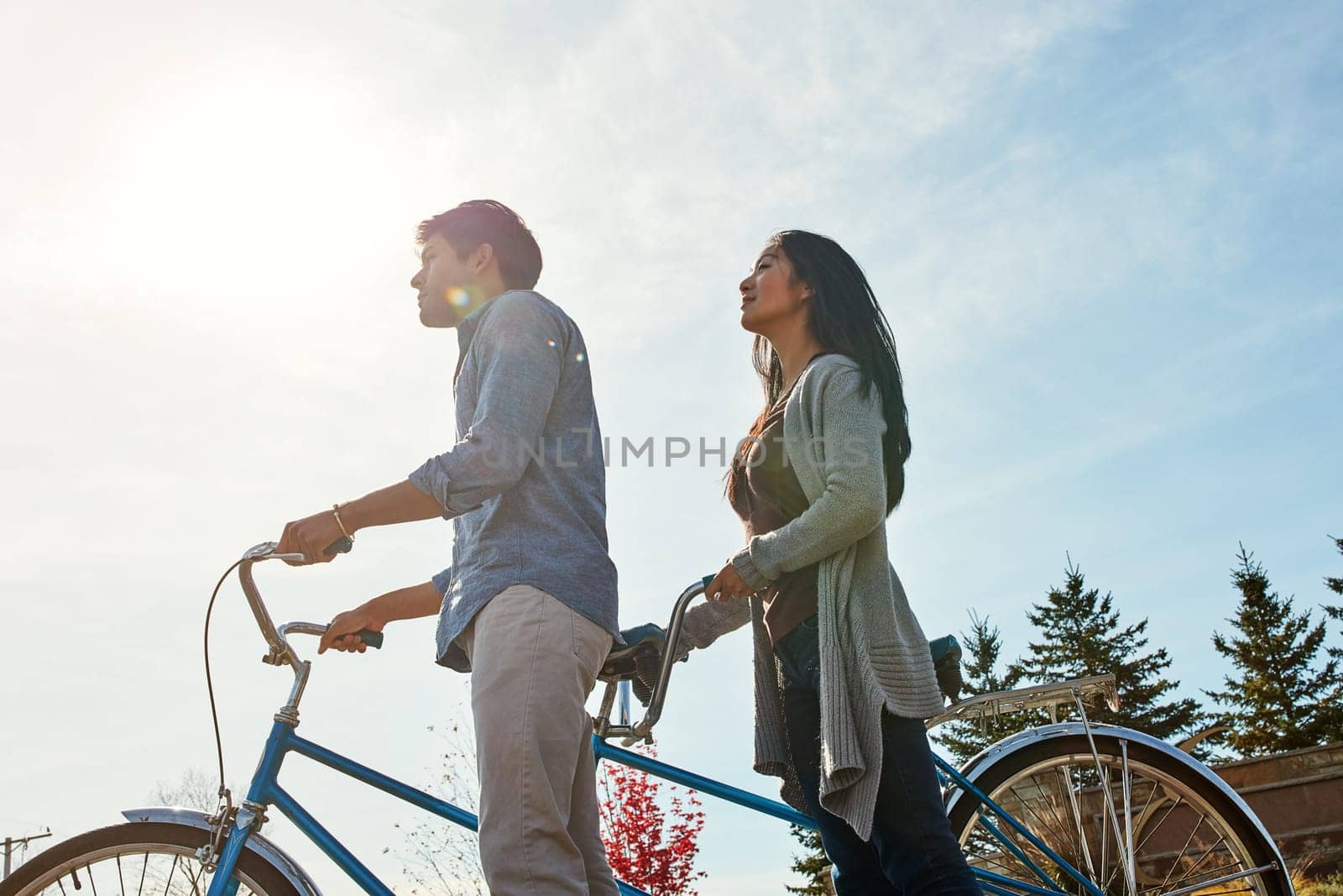 Out to see the beauty that surrounds us. a young couple out for a ride on a tandem bicycle