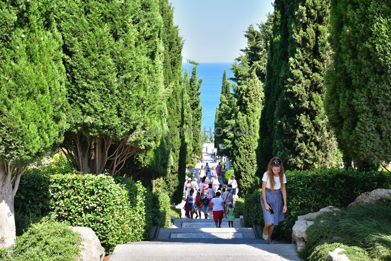 Partenit, Crimea - July 8. 2019. The People walk along the alley to the sea in Park landscape art Aivazovskoe