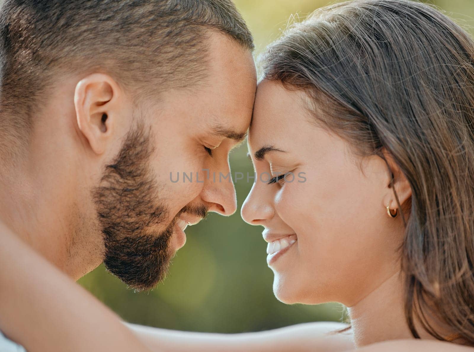 Couple, forehead and hug with smile for love, romance or embracing relationship together in the outdoors. Happy man and woman touching foreheads and hugging in happiness for loving affection outside.