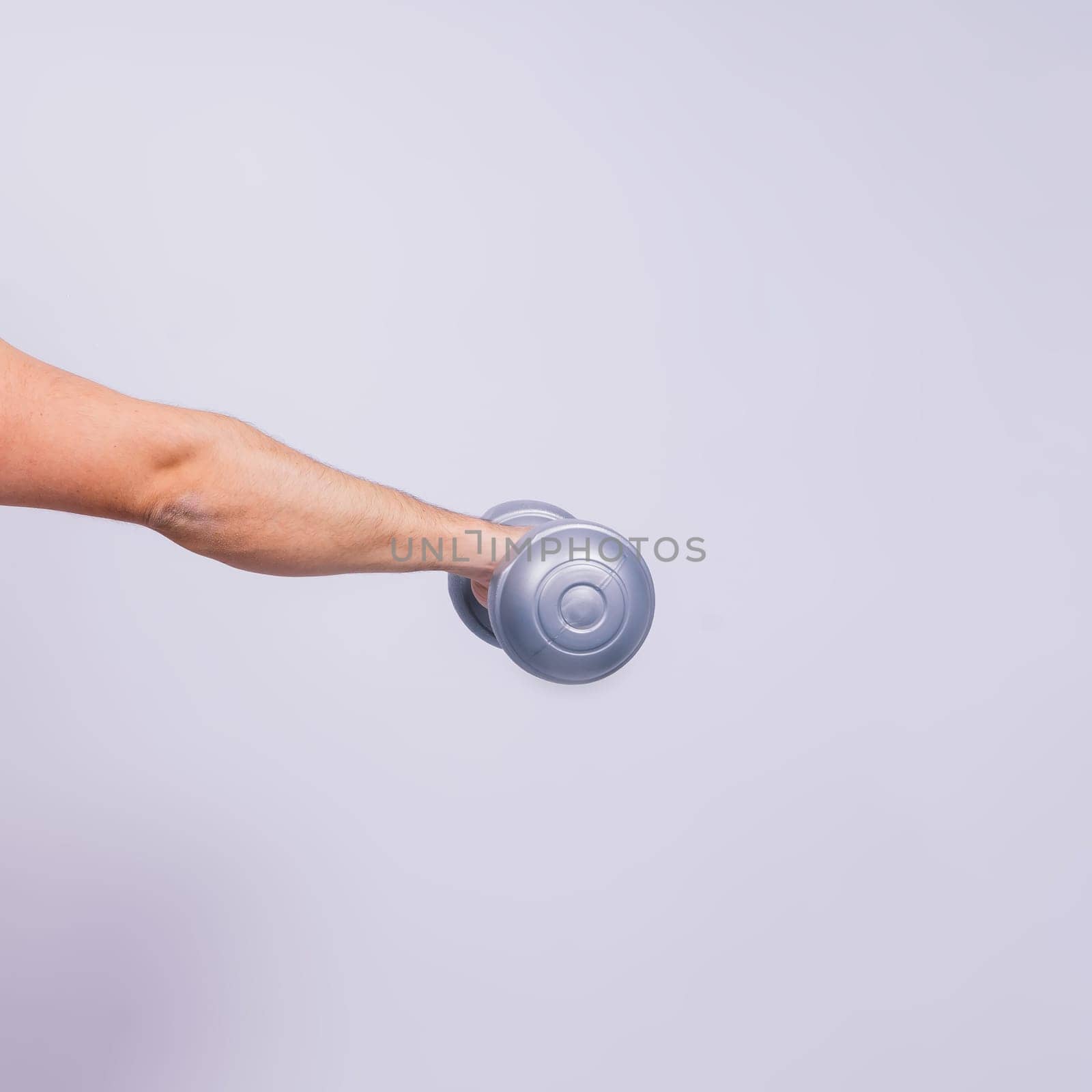 Athletic man doing exercises with dumbbell at biceps on white background. Strength and motivation by Zelenin