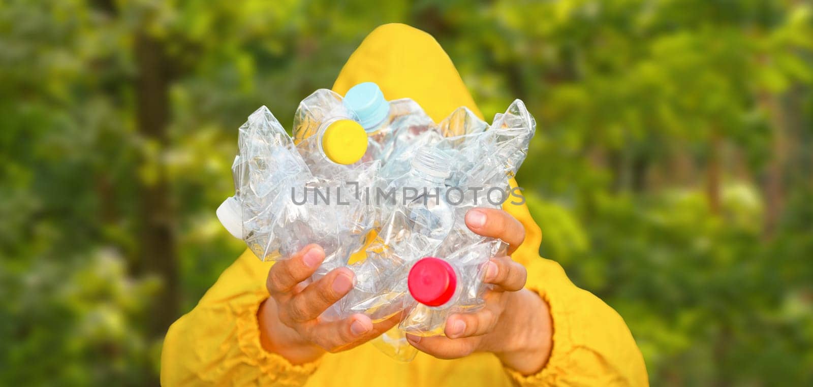 Volunteer hands holding bottle plastic garbage. Environment clean up park cleaning trash nature. Volunteer cleaning forest. PET waste plastic hand trash pick up garbage nature. PET plastic pollution by synel
