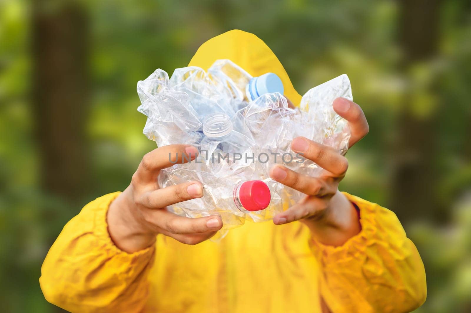 Environment clean up park cleaning trash nature. Volunteer hands holding bottle plastic garbage. Volunteer cleaning forest. PET waste plastic hand trash pick up garbage nature. PET plastic pollution by synel