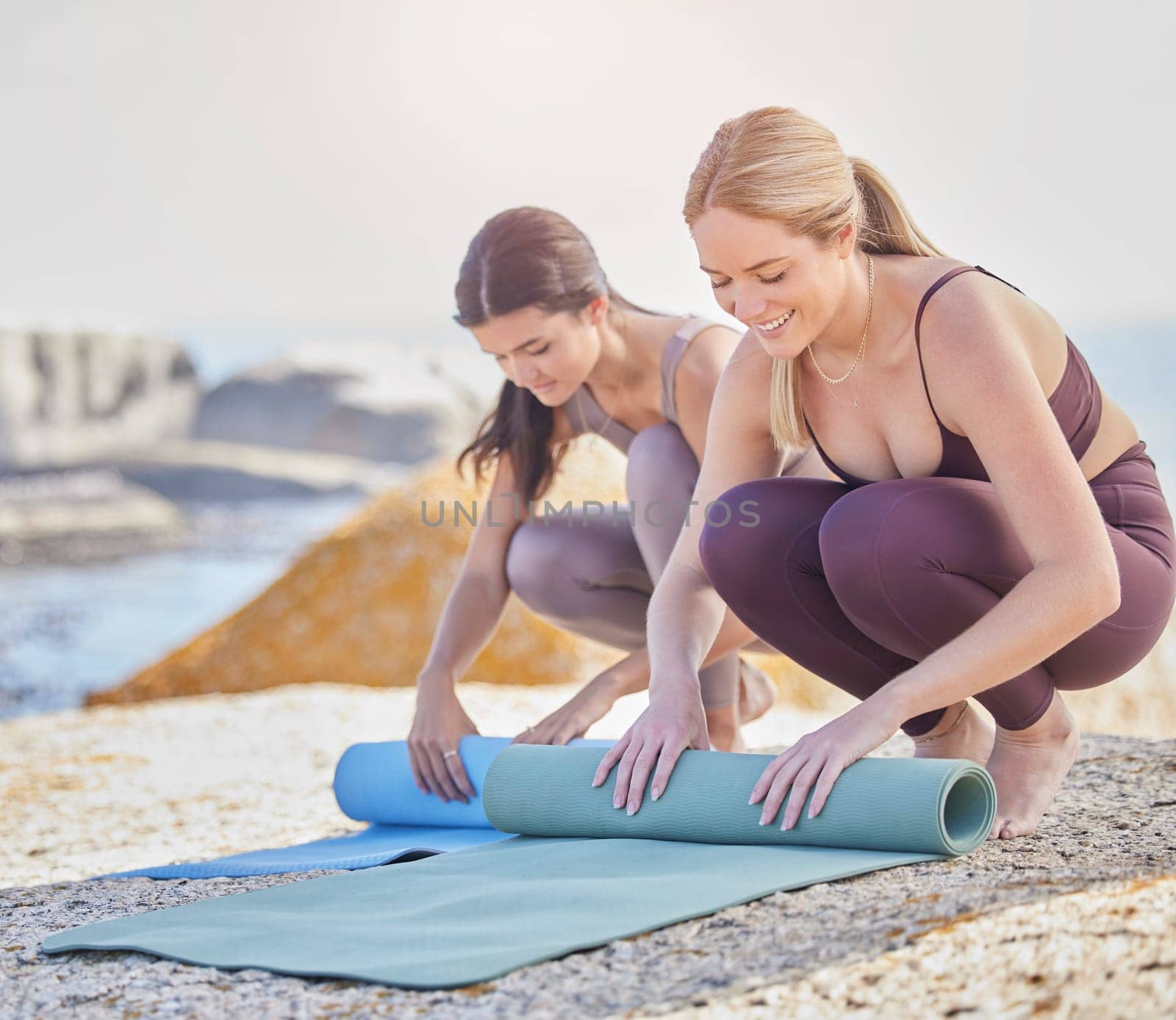 Yoga, outdoor and women with exercise mat in nature for fitness, peace and wellness. Happy friends at the beach to finish training workout with energy for mental health, balance and zen or bonding.