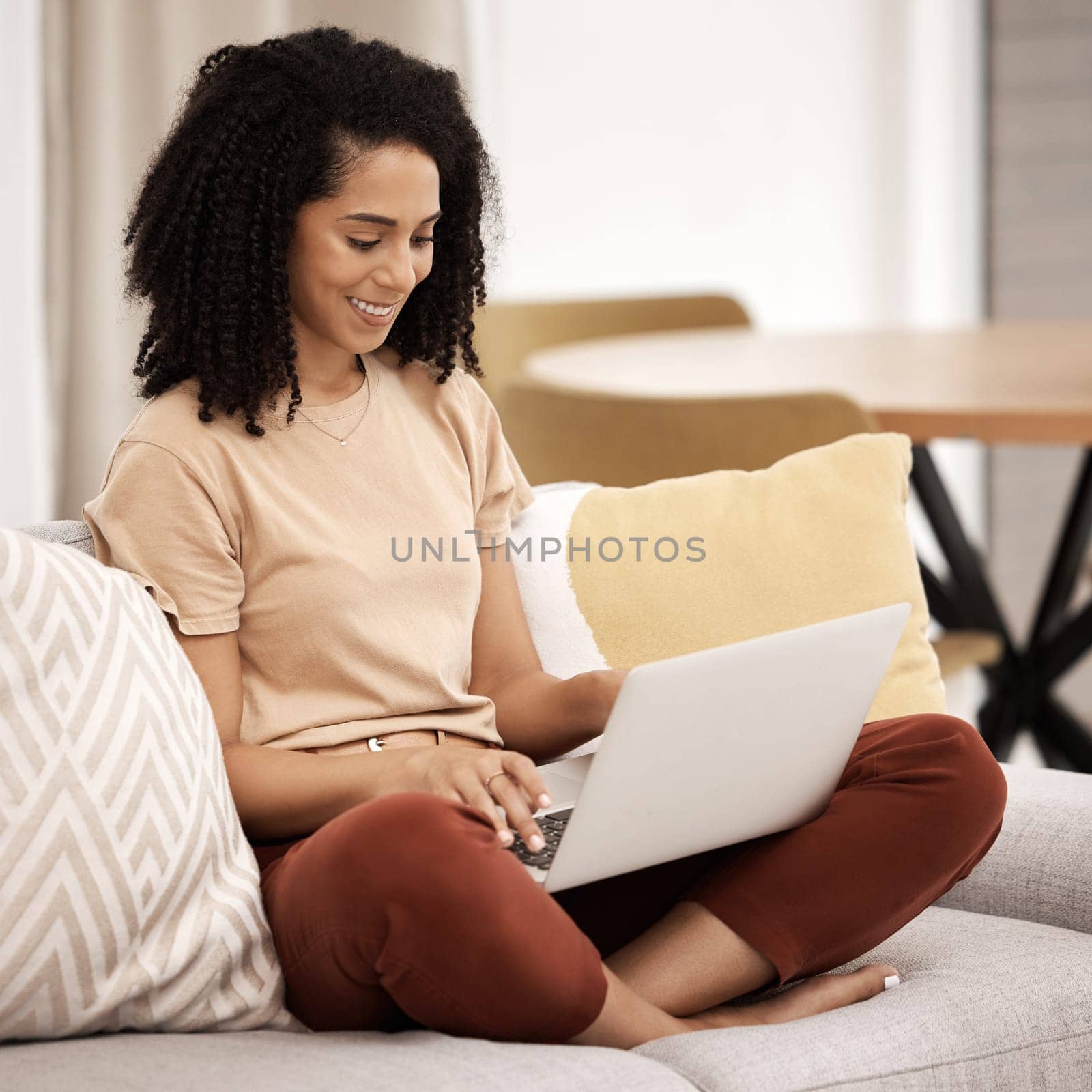 Remote work, black woman and living room sofa of person at home on a laptop working. Digital employee and woman on a sofa using technology for digital marketing job online on a computer and couch.