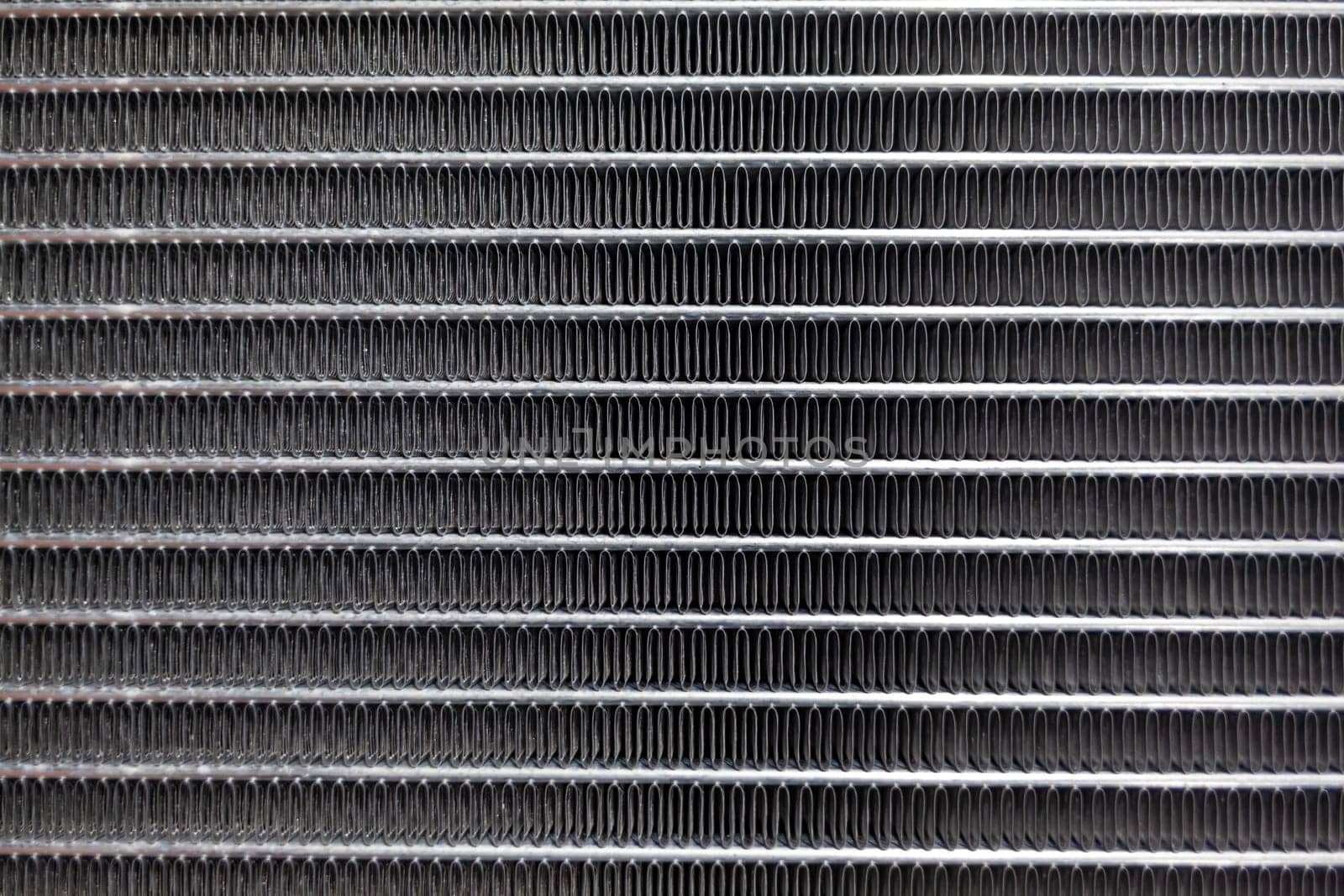 Texture of a car radiator. Engine cooler background. Vintage style. Radiator grille for car interior heater air conditioner, close-up. Radiator repair and replacement.