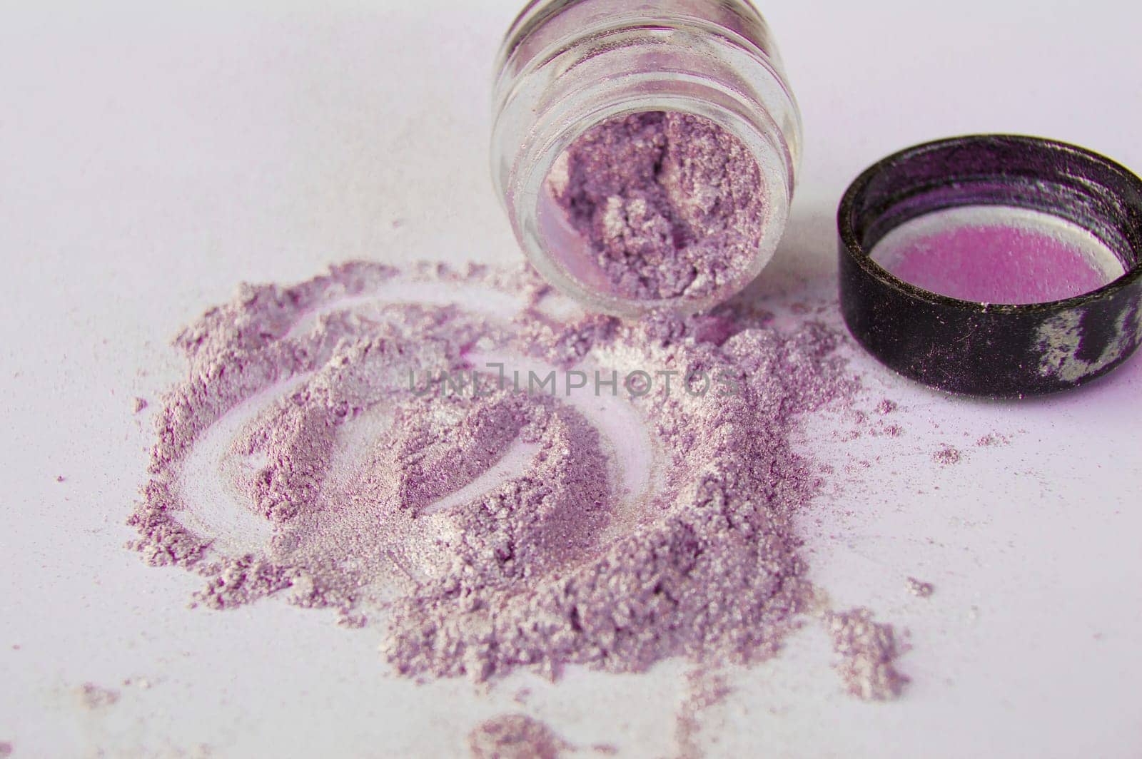Pearlescent sparkling eye shadow scattered on the table, a jar of shadows by claire_lucia