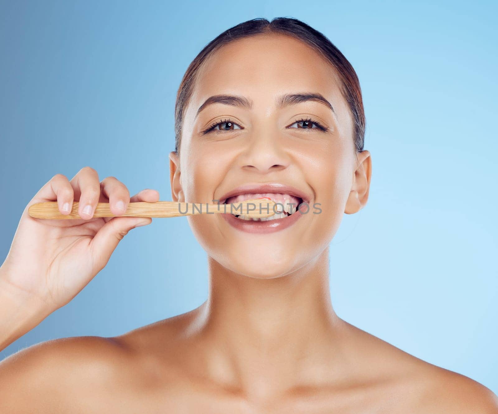 Teeth, woman and portrait of bamboo toothbrush for dental wellness, healthy cleaning or beauty cosmetics. Happy female, eco wooden brush and toothpaste of mouth, face smile and studio blue background.