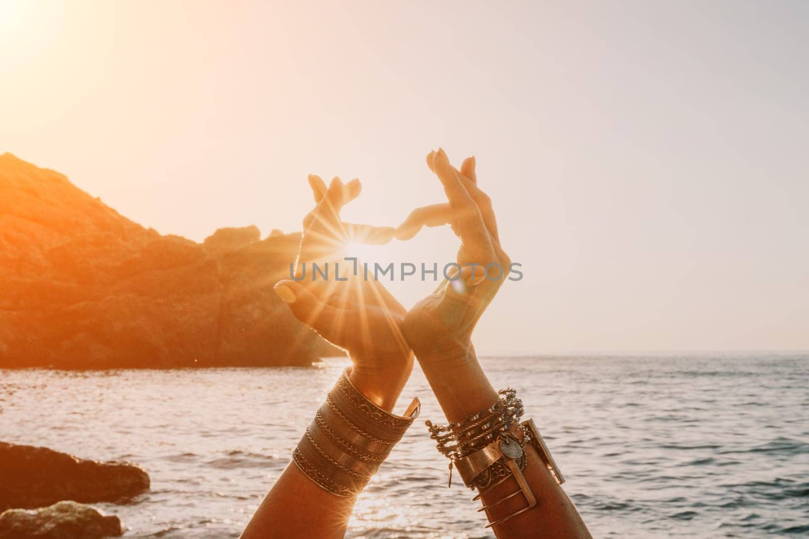 Young woman in swimsuit with long hair practicing stretching outdoors on yoga mat by the sea on a sunny day. Women's yoga fitness pilates routine. Healthy lifestyle, harmony and meditation concept.