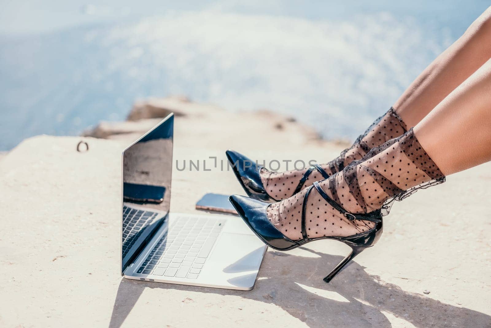 Woman sea laptop. Business woman in yellow hat freelancer with laptop working over blue sea beach. Girl relieves stress from work. Freelance, digital nomad, travel and holidays concept by panophotograph