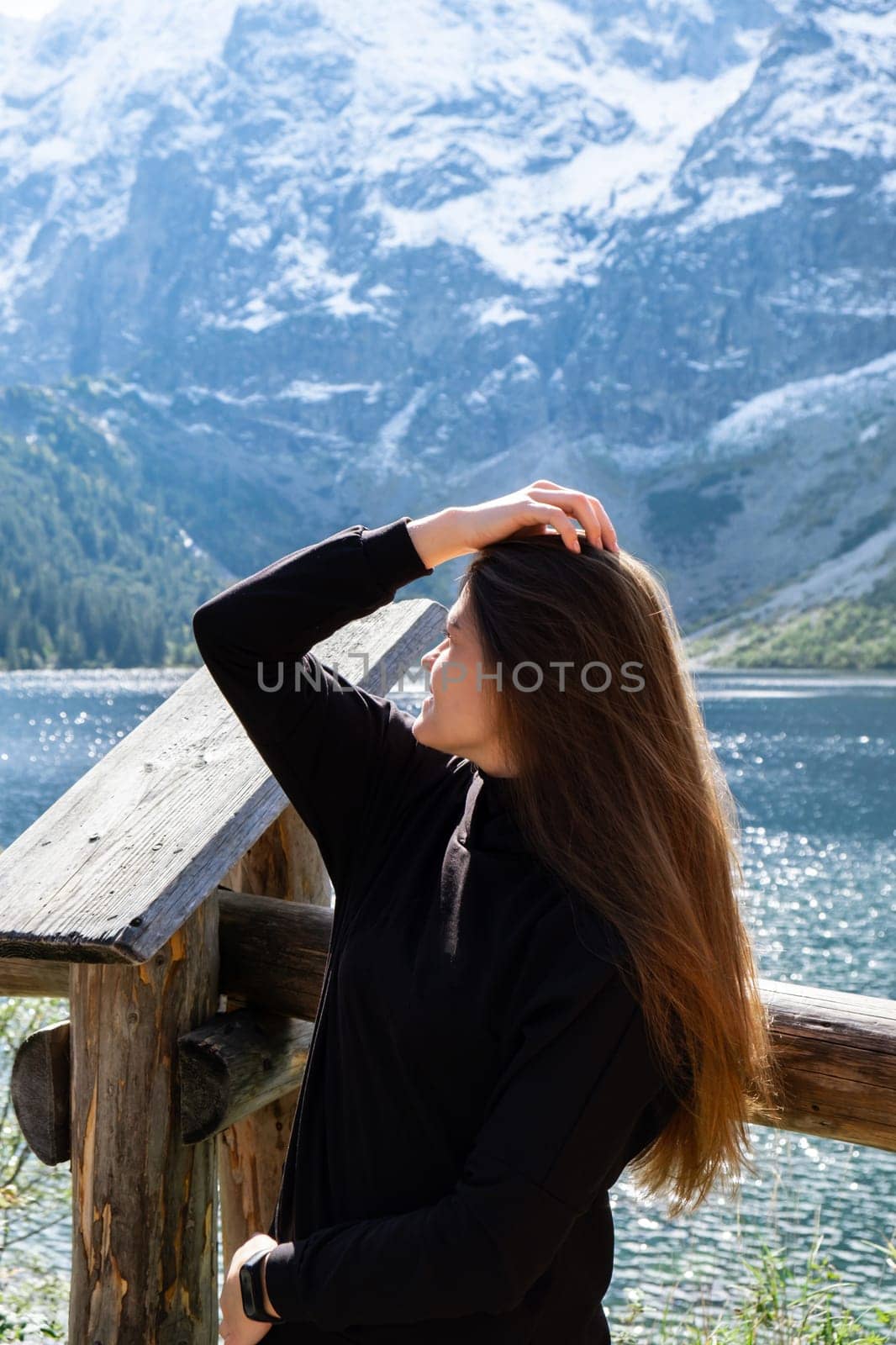 Young woman enjoying nature in Morskie Oko Snowy Mountain Hut in Polish Tatry mountains Zakopane Poland. Naturecore aesthetic beautiful green hills. Mental and physical wellbeing Travel outdoors tourist destination