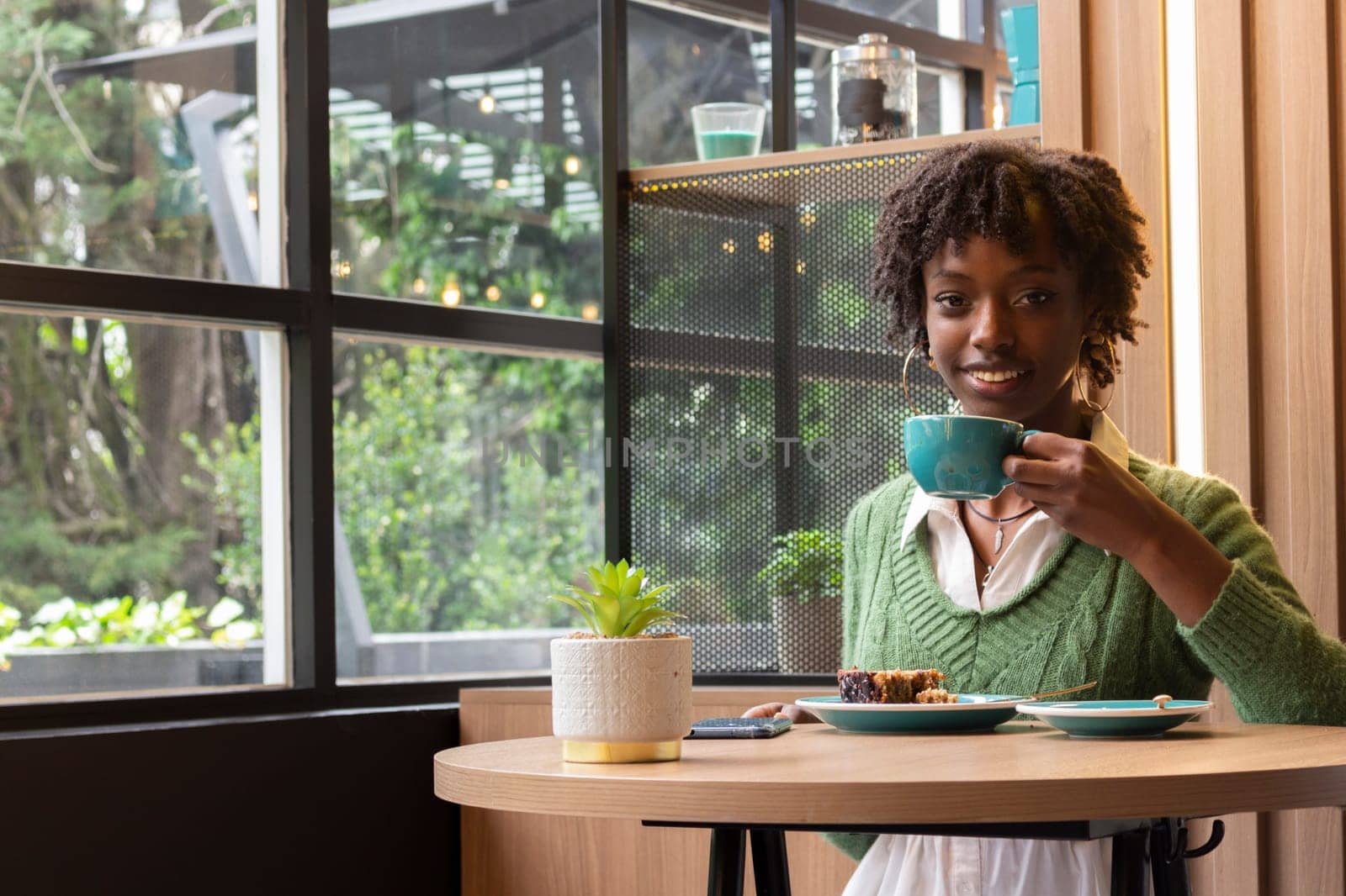 copyspace of happy and smiling girl having a coffee relaxing looking at camera and smiling. High quality photo