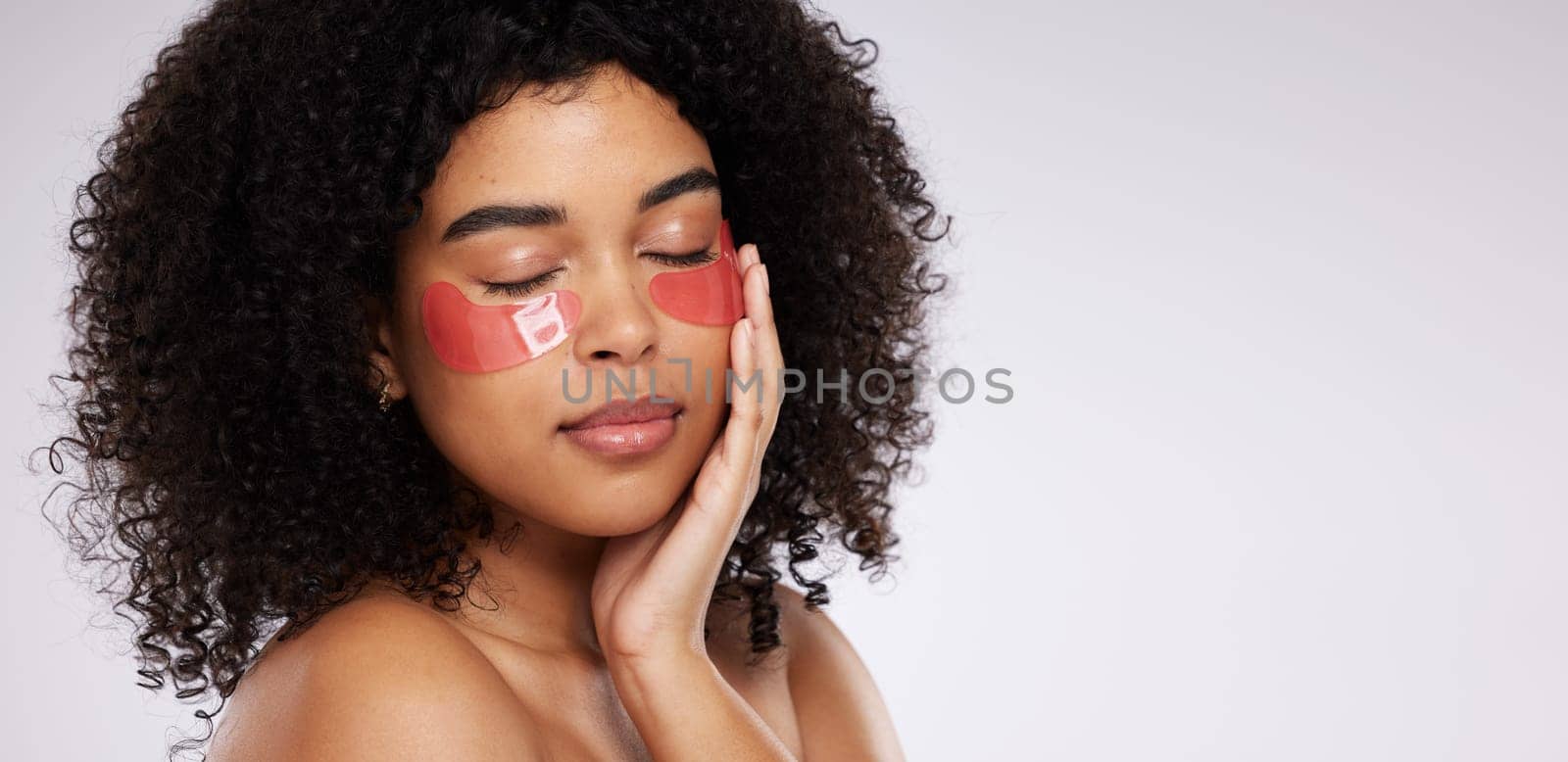 Eye mask, skincare and mockup with a model black woman in studio on a gray background for beauty or cosmetics. Spa, relax and facial with an attractive young female posing beside mock up space by YuriArcurs
