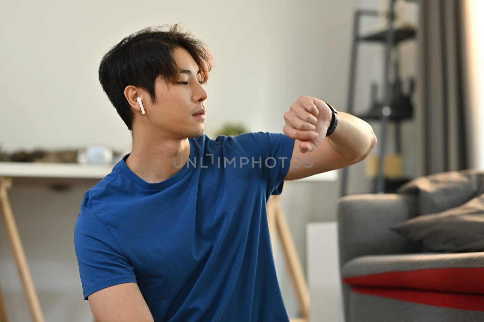 Fitness young asian man checking pulse rate on smartwatch after morning workout. Healthy lifestyle and fitness concept.