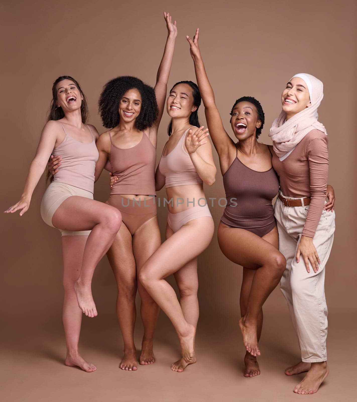 Beauty, women and celebrate diversity portrait in underwear with modest muslim woman for skincare campaign. Inclusion, happiness and body care model group with girl in hijab in brown studio. by YuriArcurs