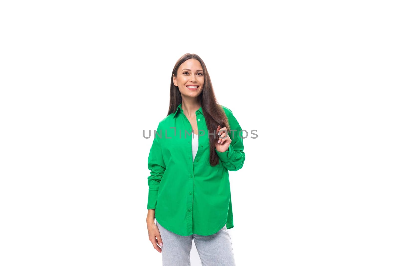 attractive young caucasian brunette lady with makeup dressed in an elegant green shirt on a white background with copy space.